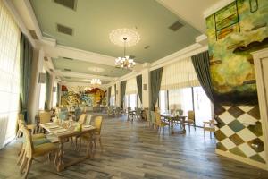 una sala da pranzo con tavoli, sedie e un dipinto di Saat Meydani Nakhchivan a Naxçıvan
