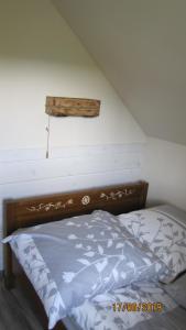 a bed with a wooden headboard in a room at Domek na Przylasku in Grywałd