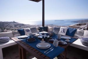 una mesa de comedor con platos azules y blancos. en ERMOUPOLIS PANORAMA ART VILLA, en Ermoupoli