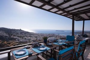 Una mesa y sillas en un balcón con vista al mar. en ERMOUPOLIS PANORAMA ART VILLA, en Ermoupoli