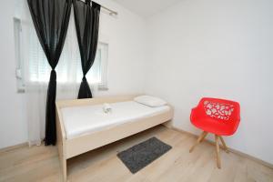 ビビニェにあるHoliday house Andrijaのベッドと赤い椅子のある寝室