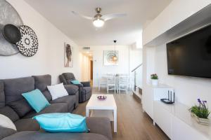 a living room with a couch and a flat screen tv at Atico en playa muchavista san juan Estrella in El Campello