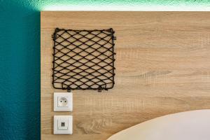 a wall with a black mesh on it and two outlets at hotelF1 Annecy Argonay in Argonay