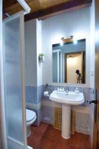 a bathroom with a sink and a toilet and a mirror at La Buhardilla de Andrea in Cuenca