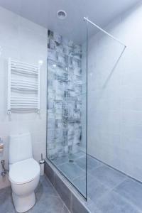 e bagno con servizi igienici e doccia in vetro. di Wehost Apartment Near Liberty Square a Tbilisi City