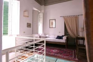 a living room with a white couch and a window at Relais Sassetti in Pisa