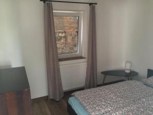 a bedroom with a bed and a window and a table at Apartmán Židovice in Louny