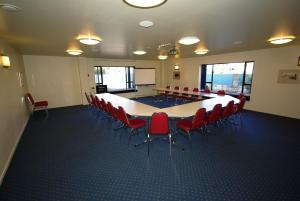 una sala de conferencias con una mesa grande y sillas en Abbots Hamilton – Hotel and Conference Centre, en Hamilton