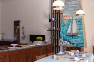 a dining room with a large painting of a sailboat on the wall at B&B Luci a'mmare in Roseto degli Abruzzi