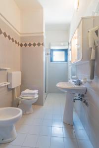 a white bathroom with a toilet and a sink at Residence Baltic in Cattolica +32 photos