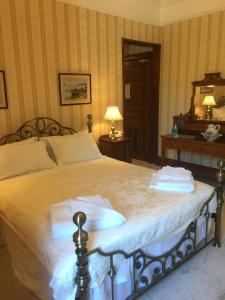 A bed or beds in a room at Ledgowan Lodge Hotel 