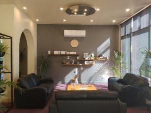 ein Wohnzimmer mit 2 Ledersesseln und einem Tisch in der Unterkunft Madison Spa Motel - Adults Only in Moama