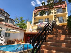a swimming pool with stairs next to a building at Family Hotel Central in Kranevo
