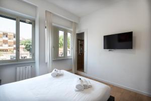 una camera da letto bianca con un letto e asciugamani di St. Paul Palace Relais a Roma