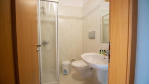 a bathroom with a shower and a toilet and a sink at Sun N Blue Hotel in Sarandë