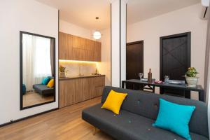 ein Wohnzimmer mit einem Sofa und einer Küche in der Unterkunft Wehost Apartment for 3 in Tbilisi City