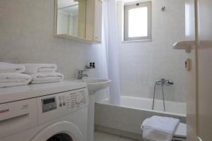 a white bathroom with a washing machine and a sink at Forum City Apartments in Chania +59 photos