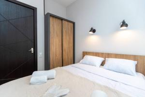 ein Schlafzimmer mit einem Bett mit zwei weißen Handtüchern darauf in der Unterkunft Wehost Apartment for 3 in Tbilisi City