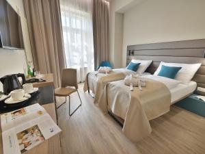 Pokój hotelowy z 2 łóżkami i biurkiem w obiekcie EA Hotel New Town w Pradze