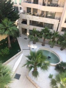 an overhead view of a building with a pool and palm trees at West bay in Menton