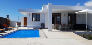 a villa with a swimming pool and a house at VILLA BLANCA in Playa Blanca