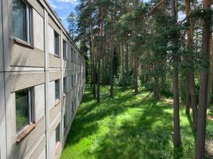 an apartment building with a green yard next to trees at Hotelli Mesku Forssa in Forssa