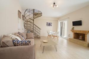 a living room with a couch and a spiral staircase at Rose Maisonette in Kefallonia