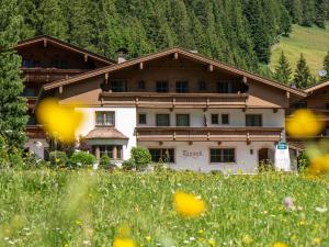 a large building in the middle of a field of flowers at Haus Tanneck in Hintertux