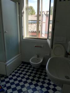 uma casa de banho com um lavatório, um WC e uma janela. em LA FURLANA em Veneza