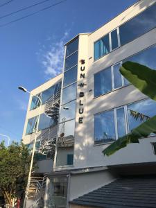 a white building with a sign on it at Sun N Blue Hotel in Sarandë