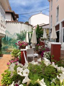 a patio with white flowers and umbrellas at Marina de Campios in Comillas