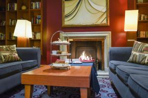 a living room with a fireplace and blue couches at Apollo Hotel in Basingstoke