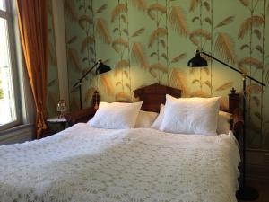 ein Schlafzimmer mit einem weißen Bett mit zwei Kissen in der Unterkunft B&B Direktörsvillan Oaxen in Mörkö