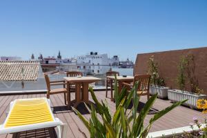 a patio with tables and chairs on a roof at Hotel Don Paco in Seville