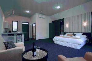 a bedroom with a bed and a living room at Hawkdun Lodge Motel in Ranfurly