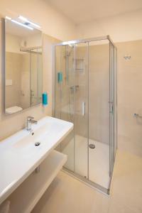 La salle de bains est pourvue d'une douche en verre et d'un lavabo. dans l'établissement Hotel Delle Nazioni, à Lignano Sabbiadoro