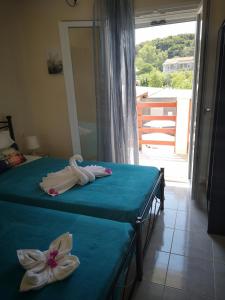 sypialnia z 2 łóżkami i ręcznikami w obiekcie Apartment Alexis Armeno w mieście Marathias