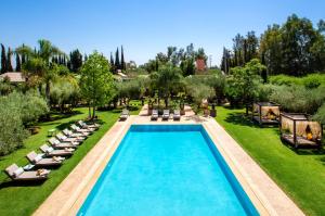 uma vista sobre uma piscina com espreguiçadeiras em Riad Jawad & Spa em Marrakech