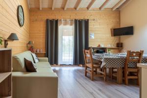 a living room with a table and a dining room at Domaine du Hirtz, Restaurant & Spa in Wattwiller