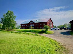a red barn with cars parked in front of it at Tiraholms hotell in Unnaryd