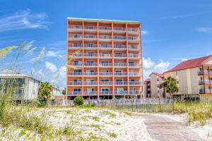 un grand immeuble situé au milieu d'une plage dans l'établissement Tropic Isle, à Gulf Shores