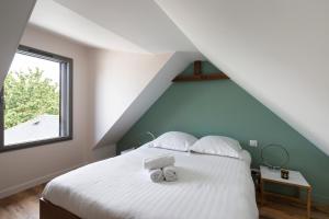 une chambre avec un lit avec deux serviettes dessus dans l'établissement L'Ernestine - Belle maison pour 4 dans Rennes, à Rennes