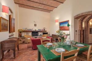 a living room with a green table and chairs at Podere Oliveta in Poggibonsi