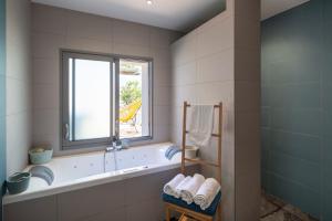 La salle de bains est pourvue d'une baignoire et d'une fenêtre. dans l'établissement L'Ernestine - Belle maison pour 4 dans Rennes, à Rennes 11 autres photos