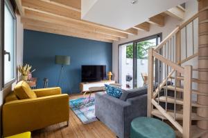 een woonkamer met blauwe muren en een trap bij Ernestine by Cocoonr in Rennes