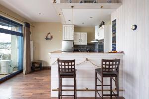 a kitchen with two chairs and a bar with a counter at La Bisquine - Appt pour 4 avec vue mer in Cancale