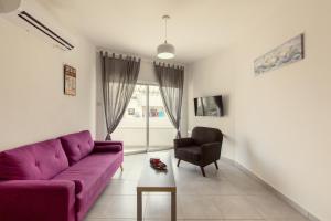 un soggiorno con divano viola e sedia di Andriana City Centre Flat a Larnaka