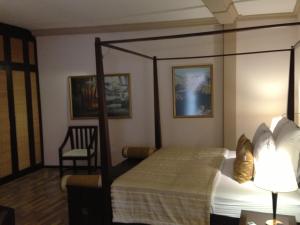 a bedroom with a canopy bed and a chair at Sala Boutique Hotel in Male City