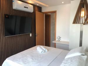 a bedroom with a bed with a flat screen tv at Palm Acqua Resort in Porto De Galinhas