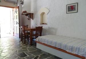 a bedroom with a bed and a table and chairs at Niriides Studios in Armenistis